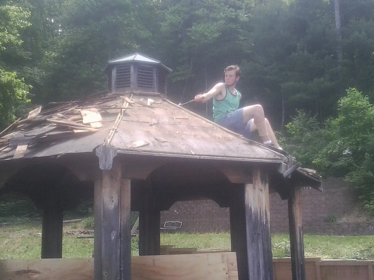 Tearing the old roof off a wooden gazebo before new shakes in Fountain