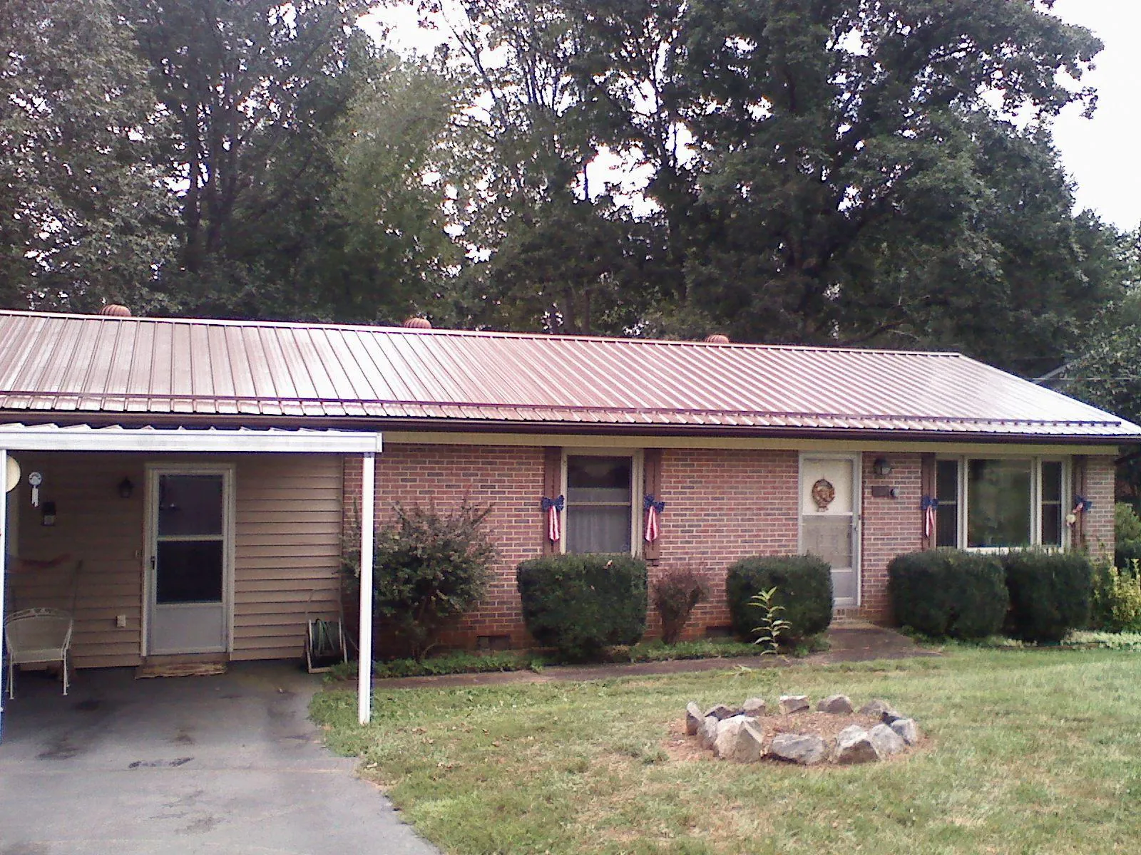 Bronze metal roof and carport on a brick ranch home — Roof Repair work by our crew in Fountain